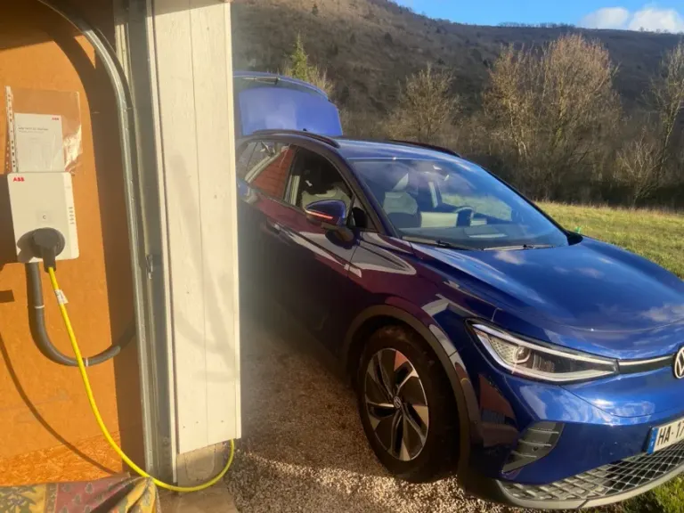 Voiture électrique en charge dans un garage sur une borne installée par Sanou Électricité